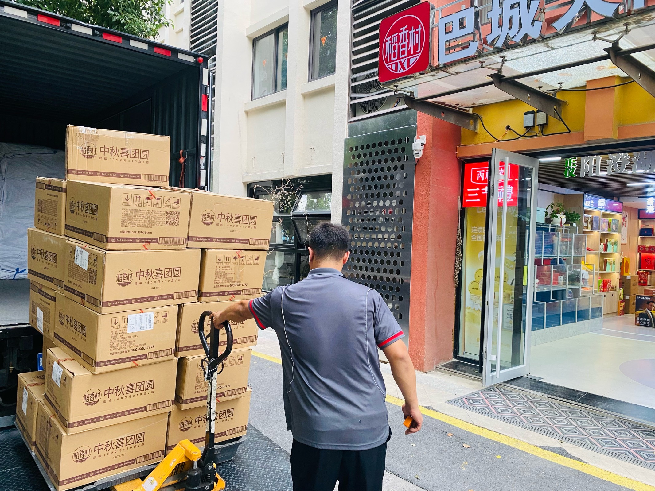 稻香村中秋喜团圆月饼礼盒在稻香村巴城门头前装车，外箱标识清晰、码放整齐
