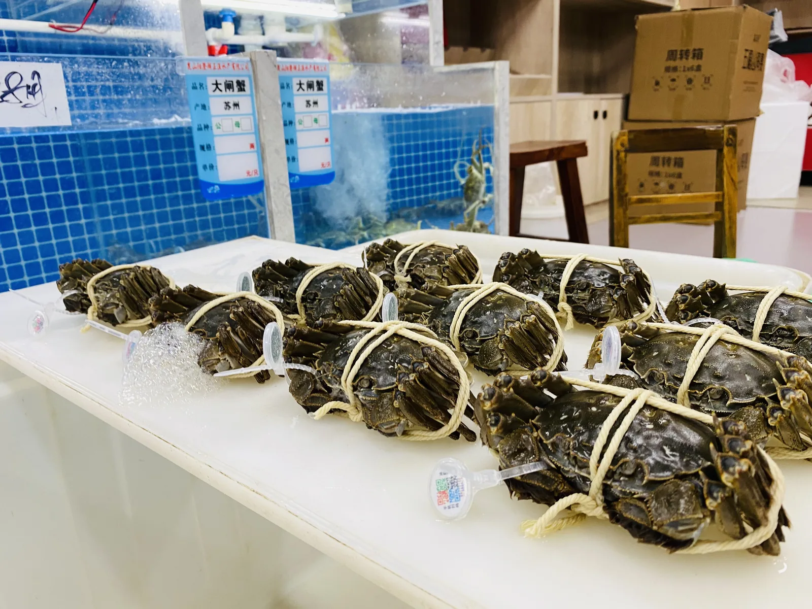 门店现场称重场景：周转箱装大闸蟹，按规格称重计价